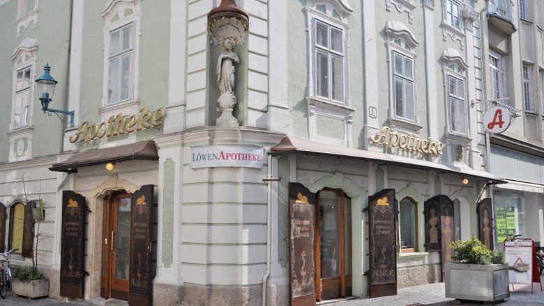 Löwen-Apotheke, © Werner Jäger Historische Apotheke mit grüner Fassade und goldener Schrift in einer Stadt.