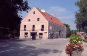 A traditional inn on a street corner decorated with flowers.