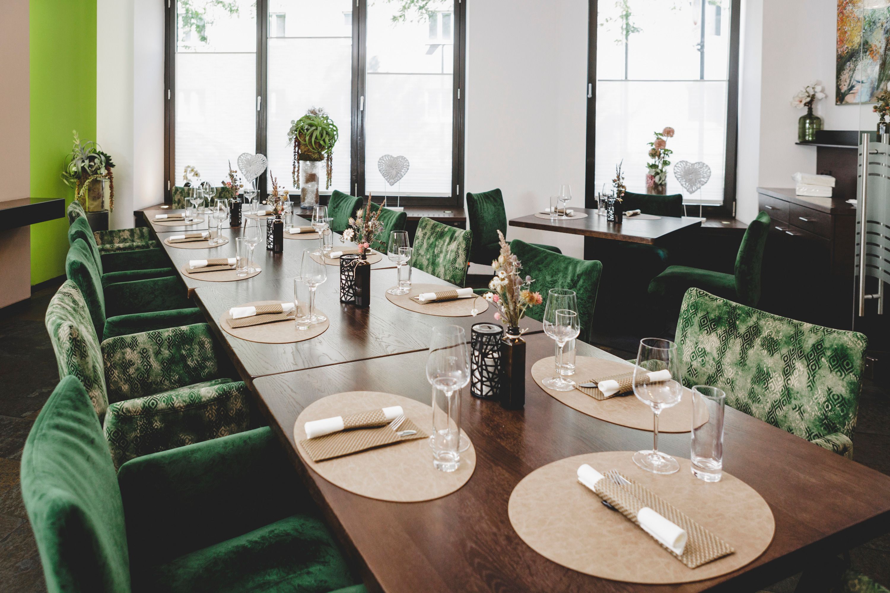 Elegantes Restaurant mit grünen Stühlen und gedecktem Tisch.