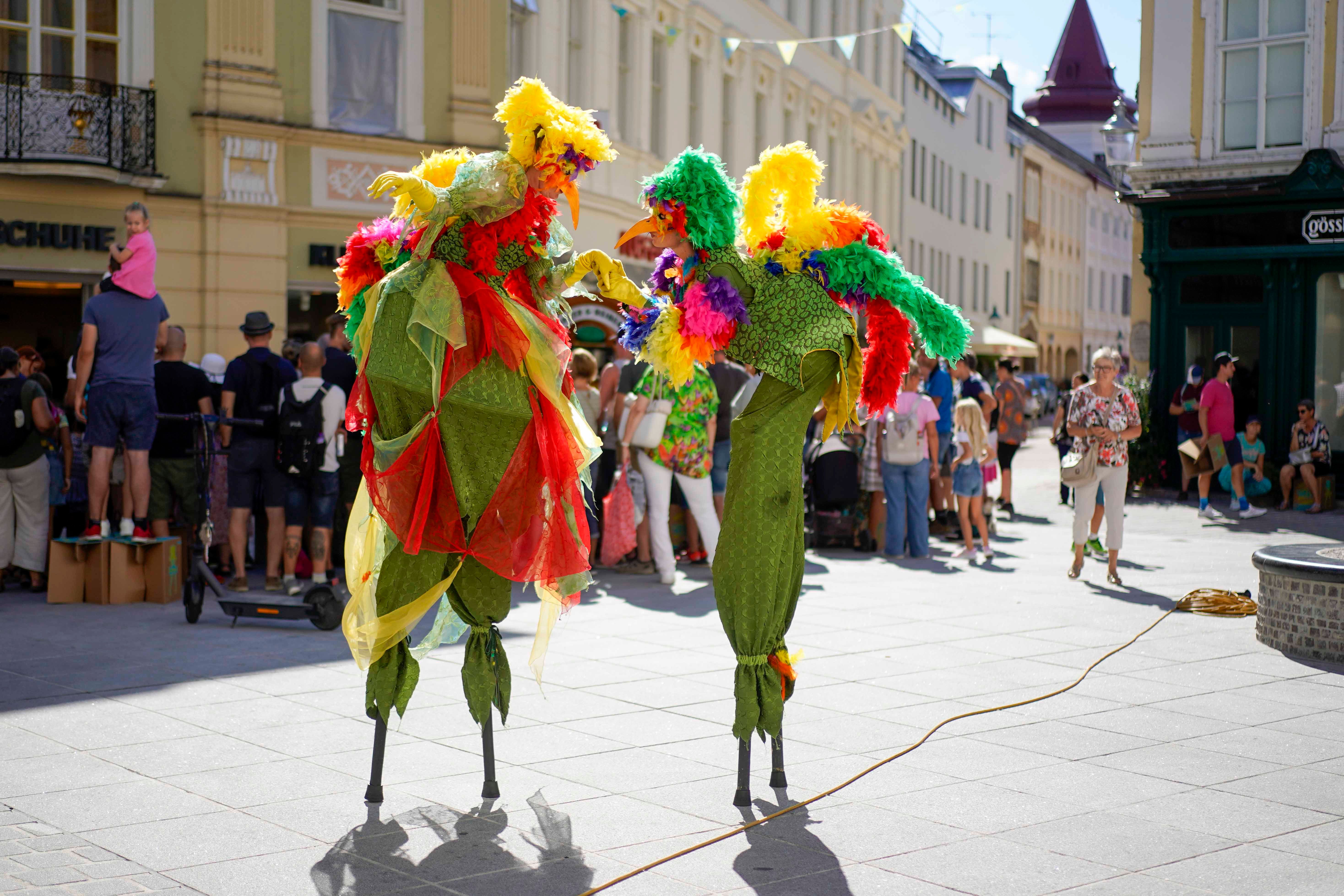 Das Straßenkunstfestival in St. Pölten zeigt internationale Künstler, die die Innenstadt beleben. Darunter Stelzengeher als bunte Vögel verkleidet.