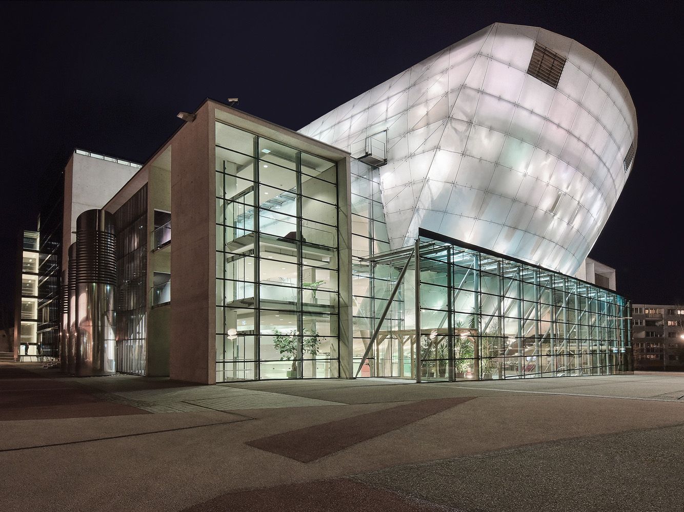 Nachtaufnahme des Festspielhauses St. Pölten mit beleuchteter moderner Architektur.