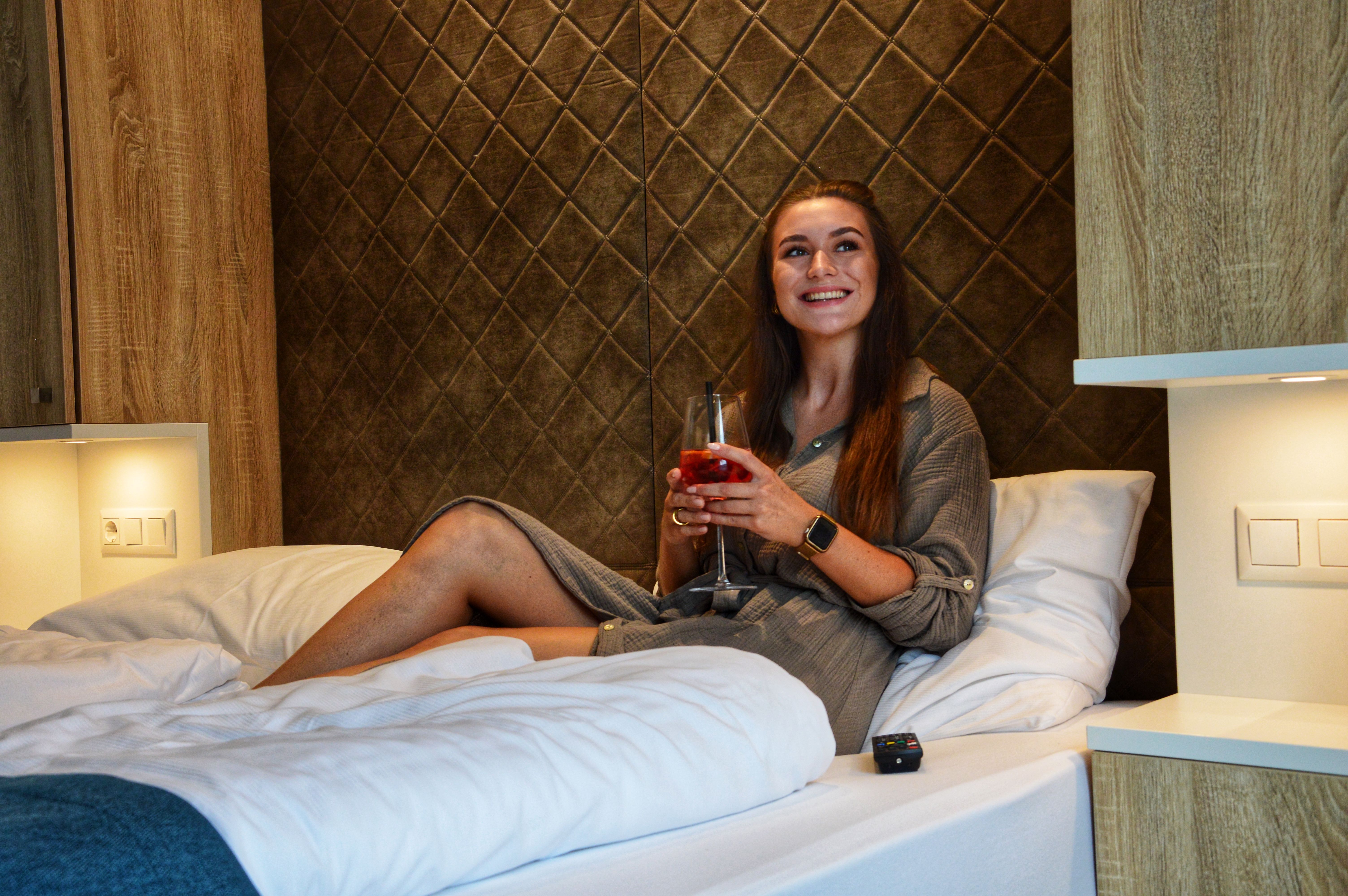 Frau genießt ein Glas Lillet Berry im Hotelzimmer. 