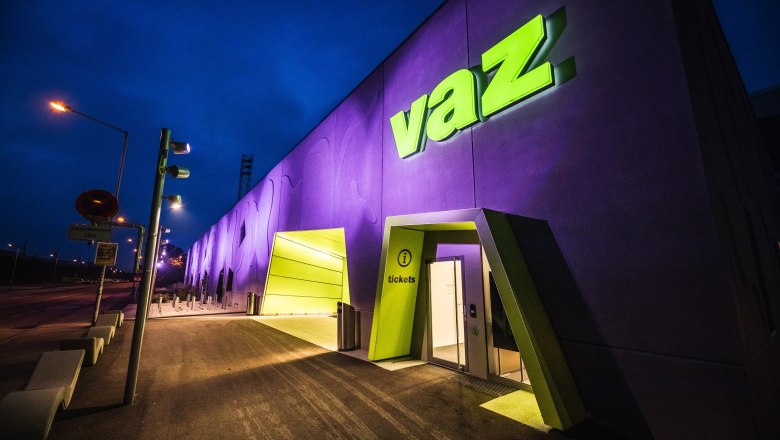 Entrance to the VAZ St. Pölten at night with illuminated sign.