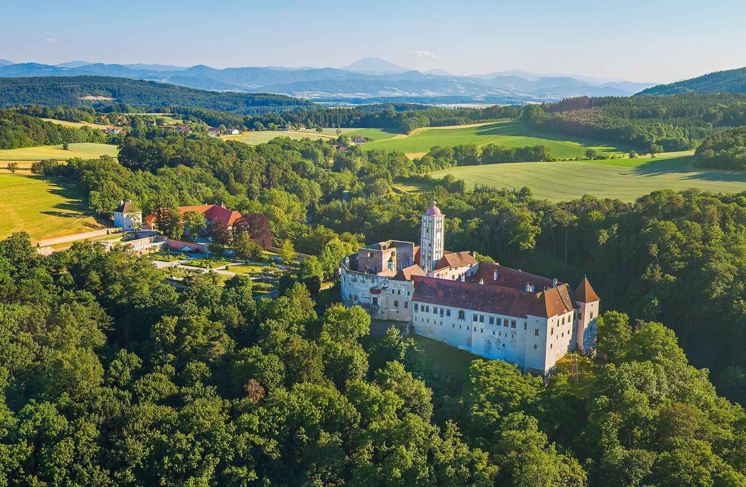 Luftaufnahme der Schallaburg inmitten grüner Landschaft.