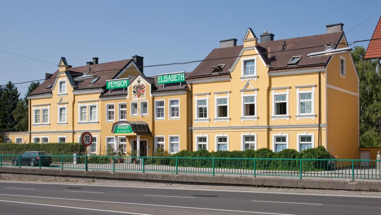 Gelbes Gebäude der Pension Elisabeth mit grünen Schildern.