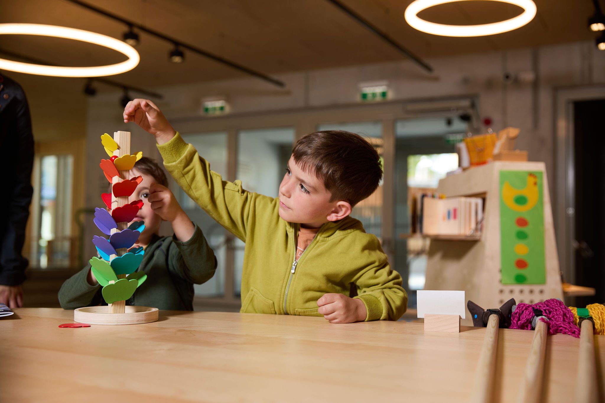 Geschwister spielen im Eingangsbereich des Kinderkunstlabors St. Pölten. 