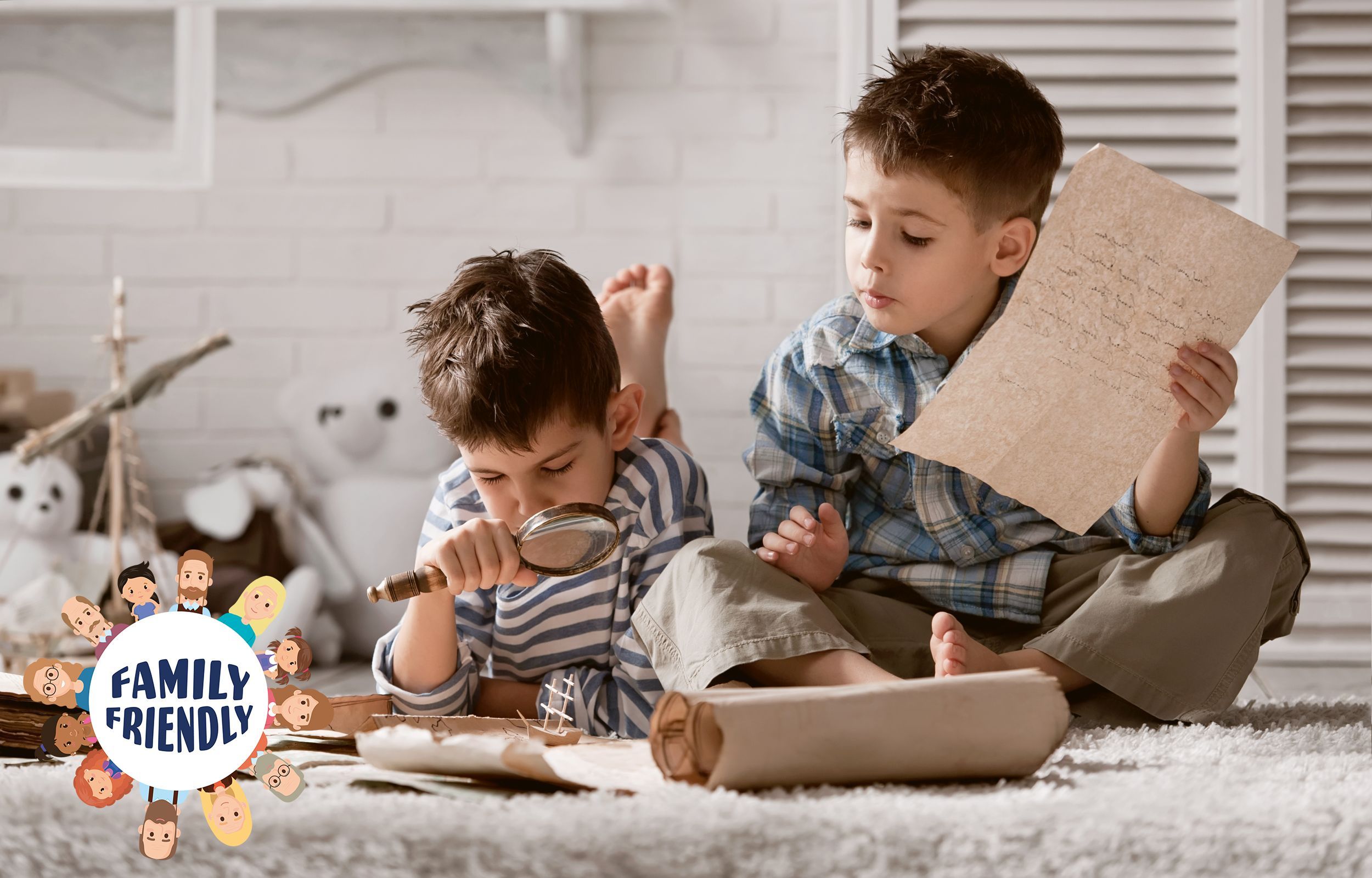family | Zu sehen sind zwei Kinder. Einer der beiden Buben sitzt am Boden und hält ein Blatt Papier 