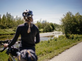 A gentle cycle path meanders along the glistening water, surrounded by lush greenery and flowering meadows. The fresh air and the gentle sounds of nature invite you to unwind and enjoy the beauty of the landscape.